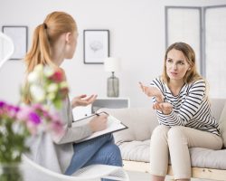 Young female patient talking with therapist in office about mental problems and worries counseling psychology concept